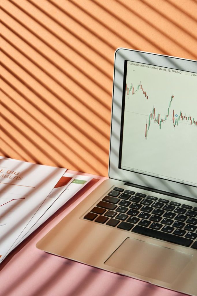Crafting Captivating Headlines: Your awesome post title goes here Laptop displaying stock market graph with shadows on desk, conveying a finance theme.